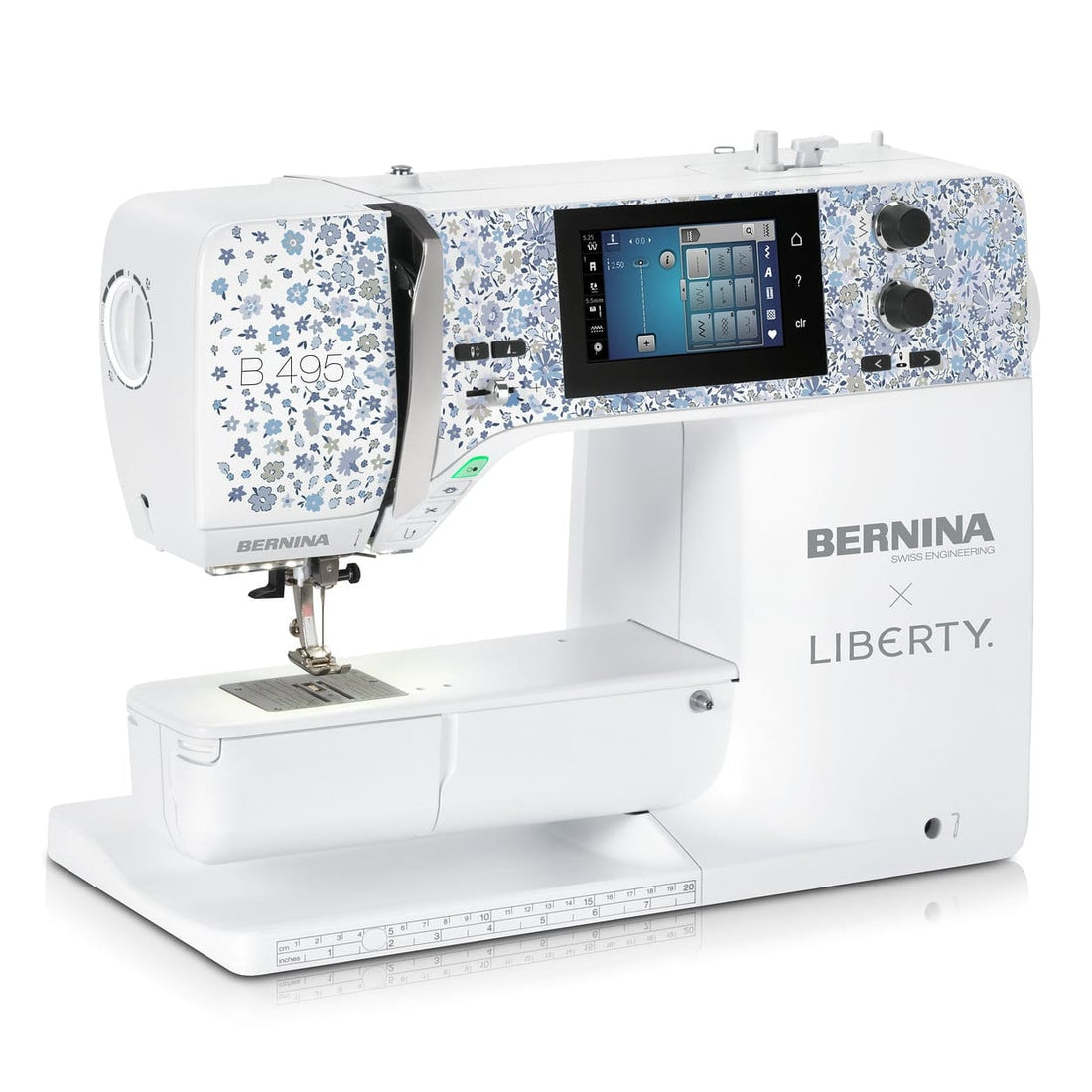 A white Bernina x Liberty sewing machine with blue floral patterned accents on the head, a digital screen, and a white base, shown on a clean white background.