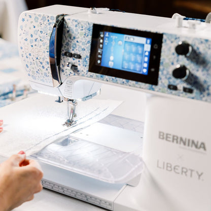 Bernina Liberty sewing machine with a person operating it on a table.