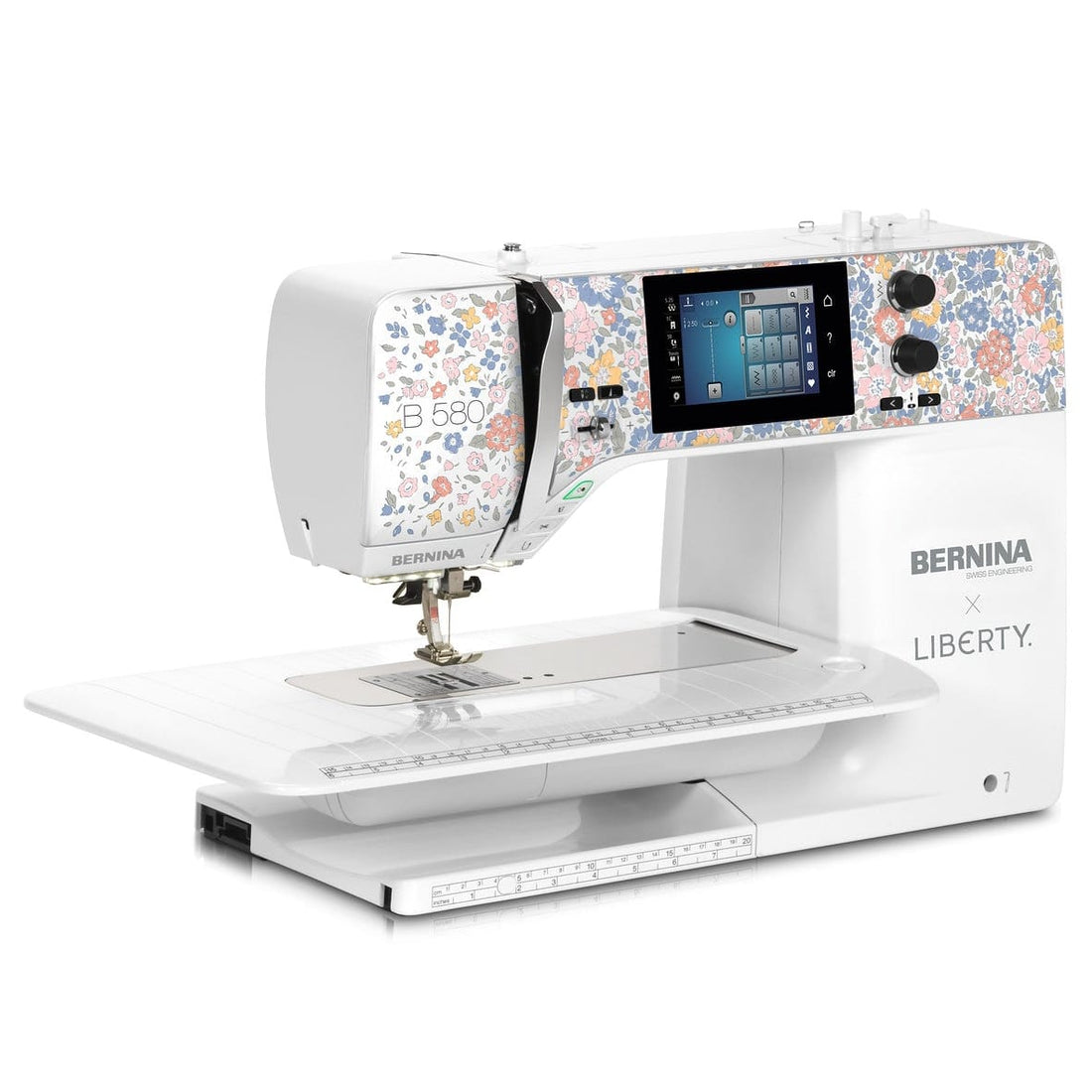 A BERNINA Liberty sewing machine in white, featuring a colorful floral pattern on the upper housing and side panels, with a digital screen and flat bed, shown on a solid white background.