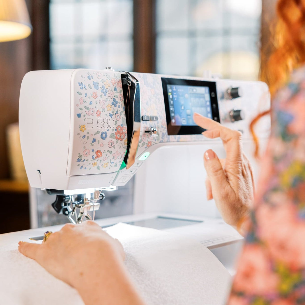 Person using a modern sewing machine in a well-lit room