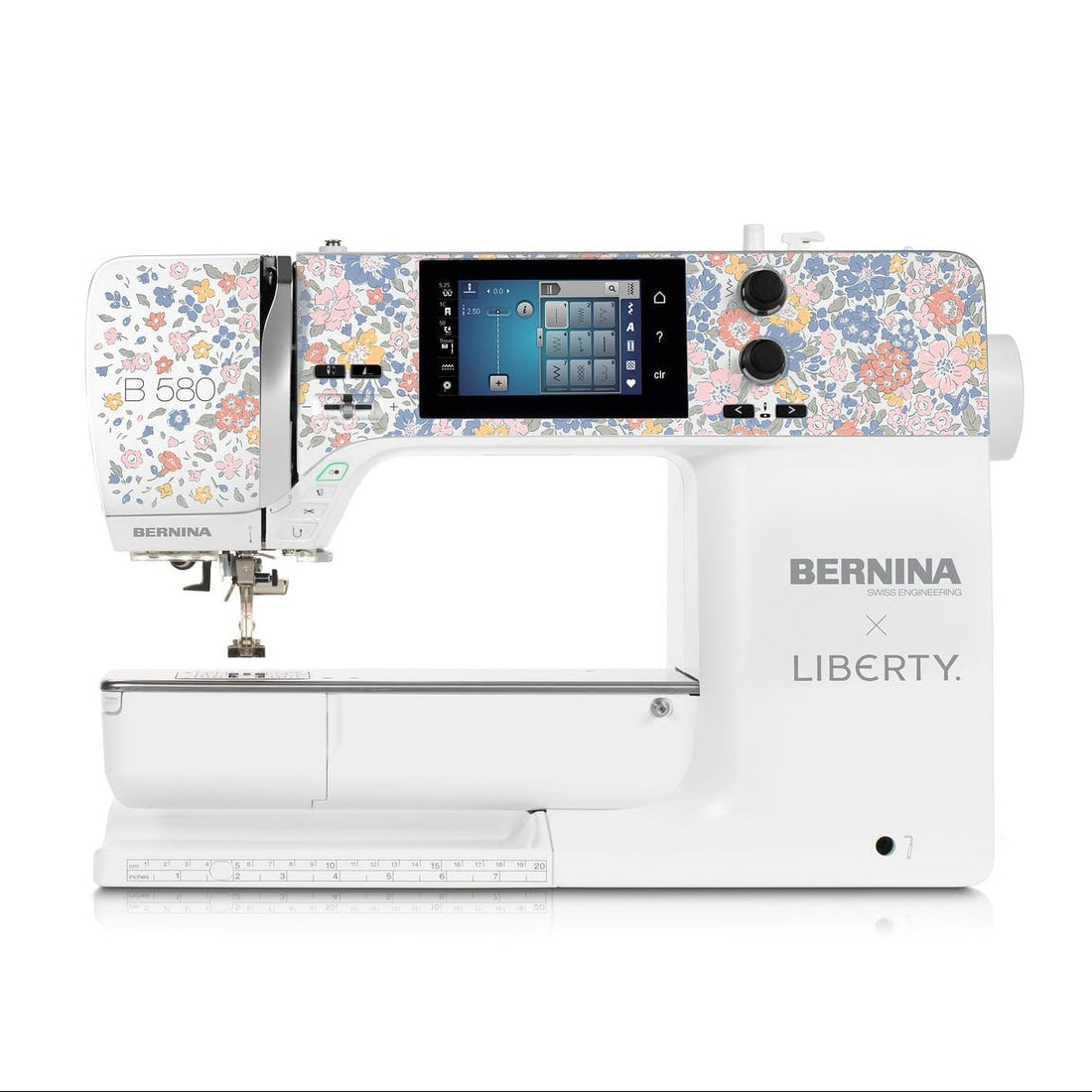 A BERNINA x LIBERTY sewing machine in white, featuring a colorful floral pattern on the upper housing and a digital display screen, shown against a plain white background.