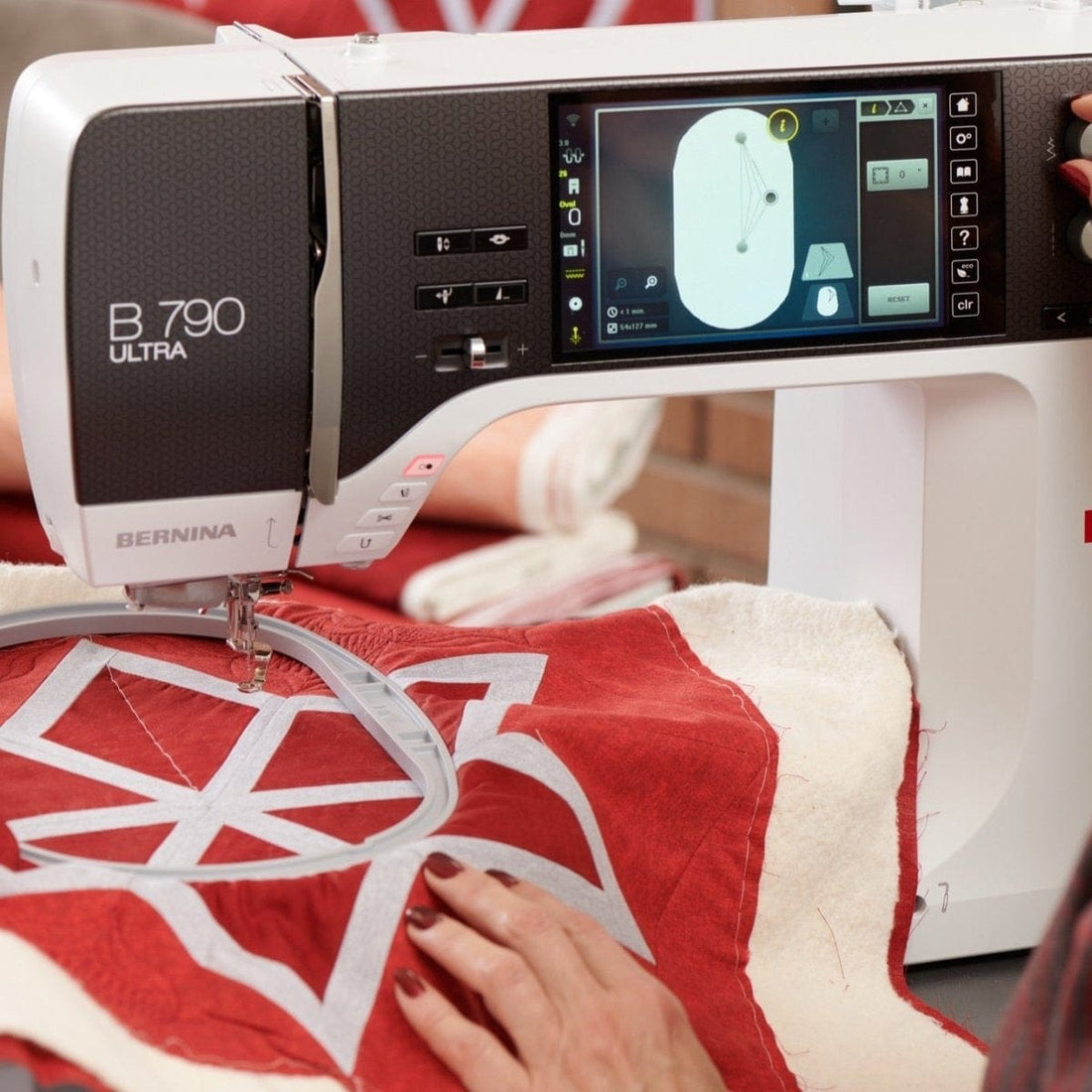 Person using a Bernina sewing machine on a red and white fabric