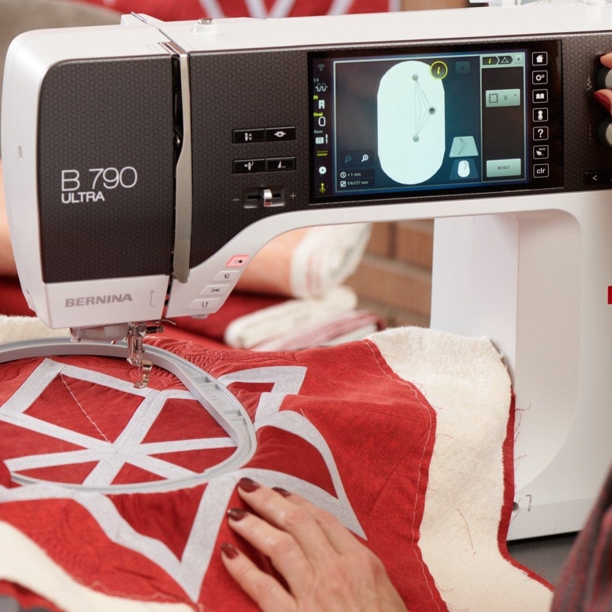 Person using a Bernina sewing machine on a red and white fabric