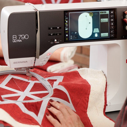 Person using a Bernina sewing machine on a red and white fabric