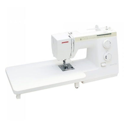 A white Janome sewing machine with an attached white straight-edge table base, shown from a three-quarters angle on a solid white background.